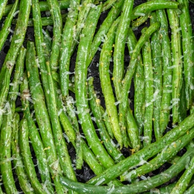 Overhead view of green beans looking into an air fryer basket.