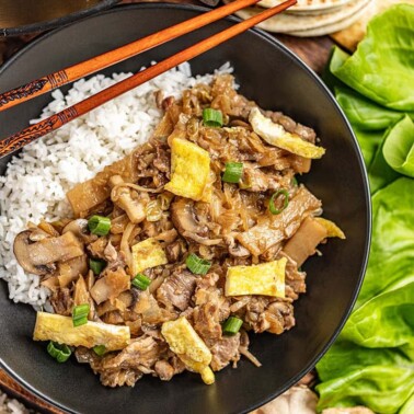 Overhead view of moo shu pork and white rice in a bowl.