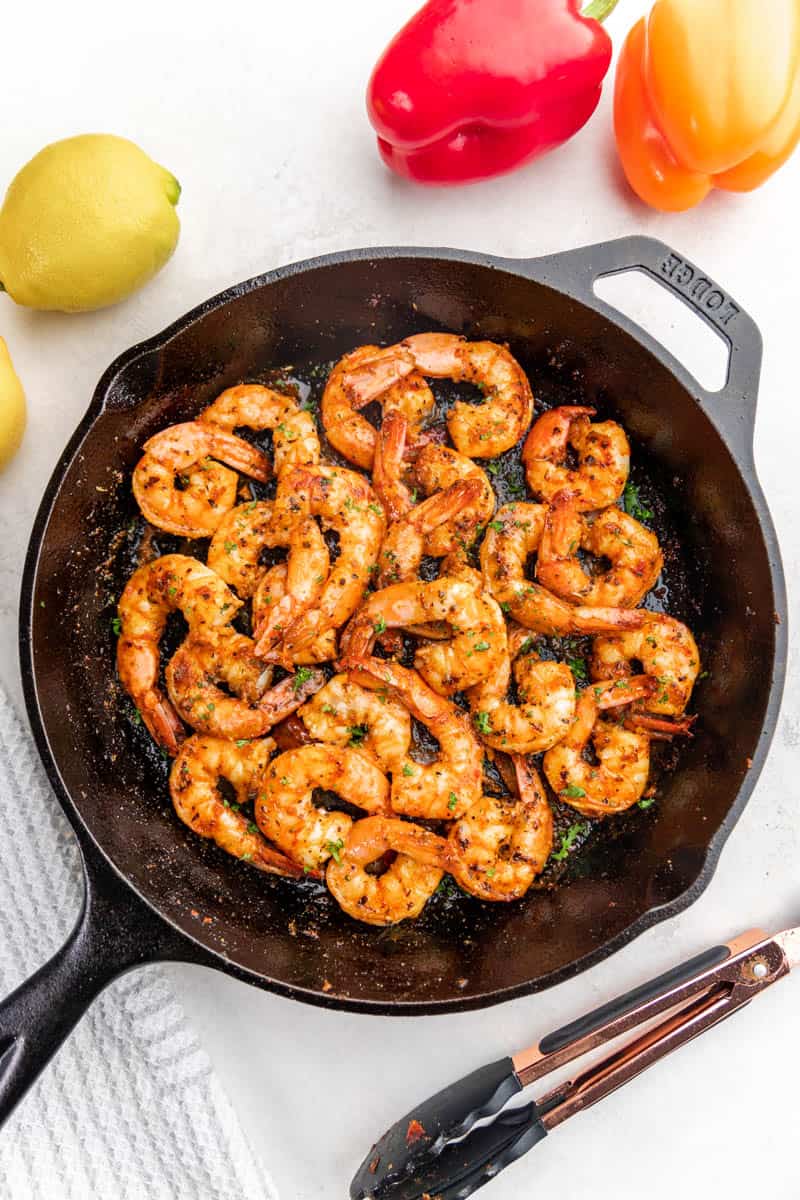 Overhead view of cajun shrimp in a cast iron skillet.