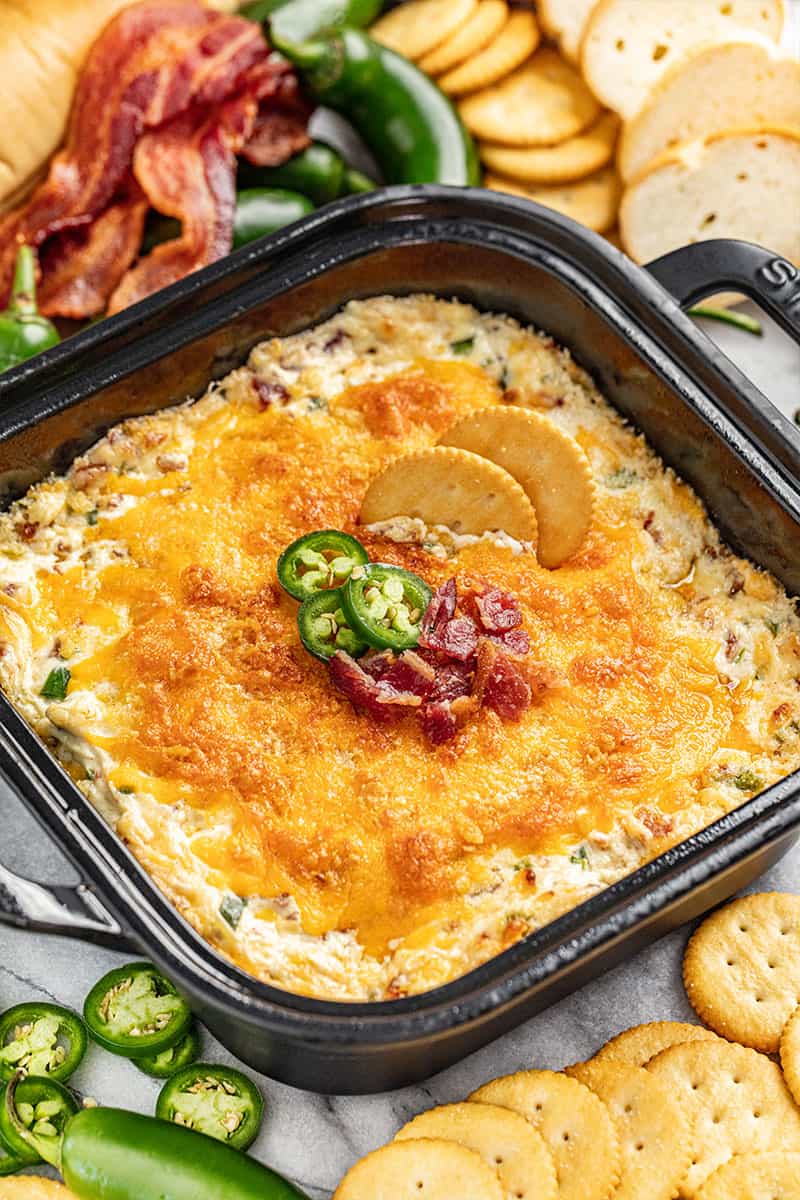 Cheesy jalapeno popper dip in a black baking dish.