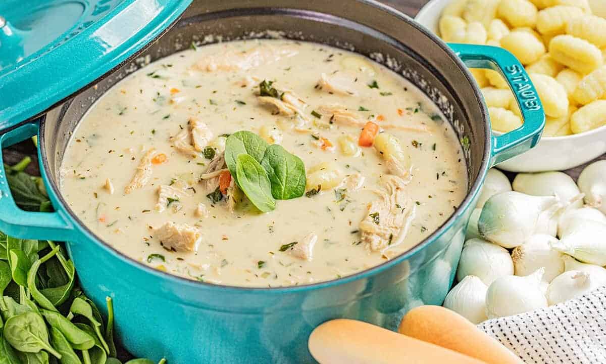 A blue stockpot filled with chicken gnocchi soup.