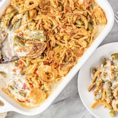 Bird's eye view of a serving of Green Bean Casserole with bacon and crunchy fried onion that has been scooped from the pan and placed on a serving plate