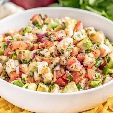 Shrimp ceviche in a white bowl surrounded by chips