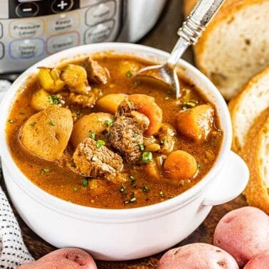 Instant pot beef stew in a small white bowl.