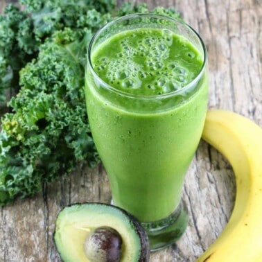 Kale avocado banana smoothie on a wood countertop.