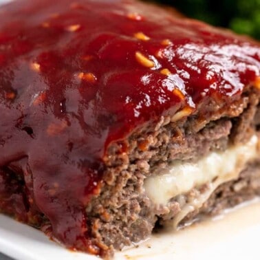 Cross-section of a loaf of Slice of Mozzarella Stuffed Meatloaf revealing the gooey mozzarella cheese inside.