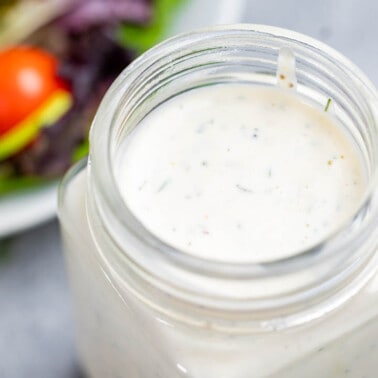 Close up view of ranch dressing in a glass jar.