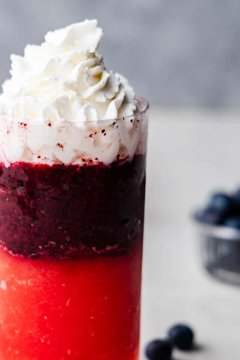 A close view of the red, white, and blue slushy showing a mountain of cream on top.