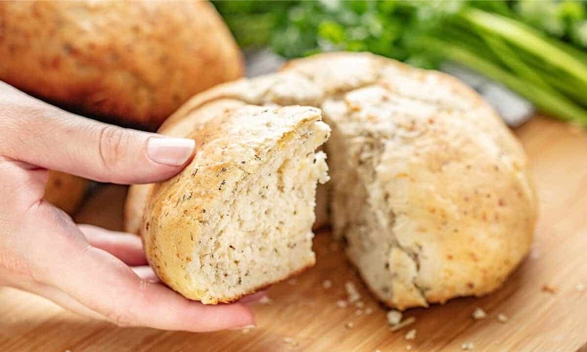 Rustic garlic parmesan herb bread, pulling a cut piece off