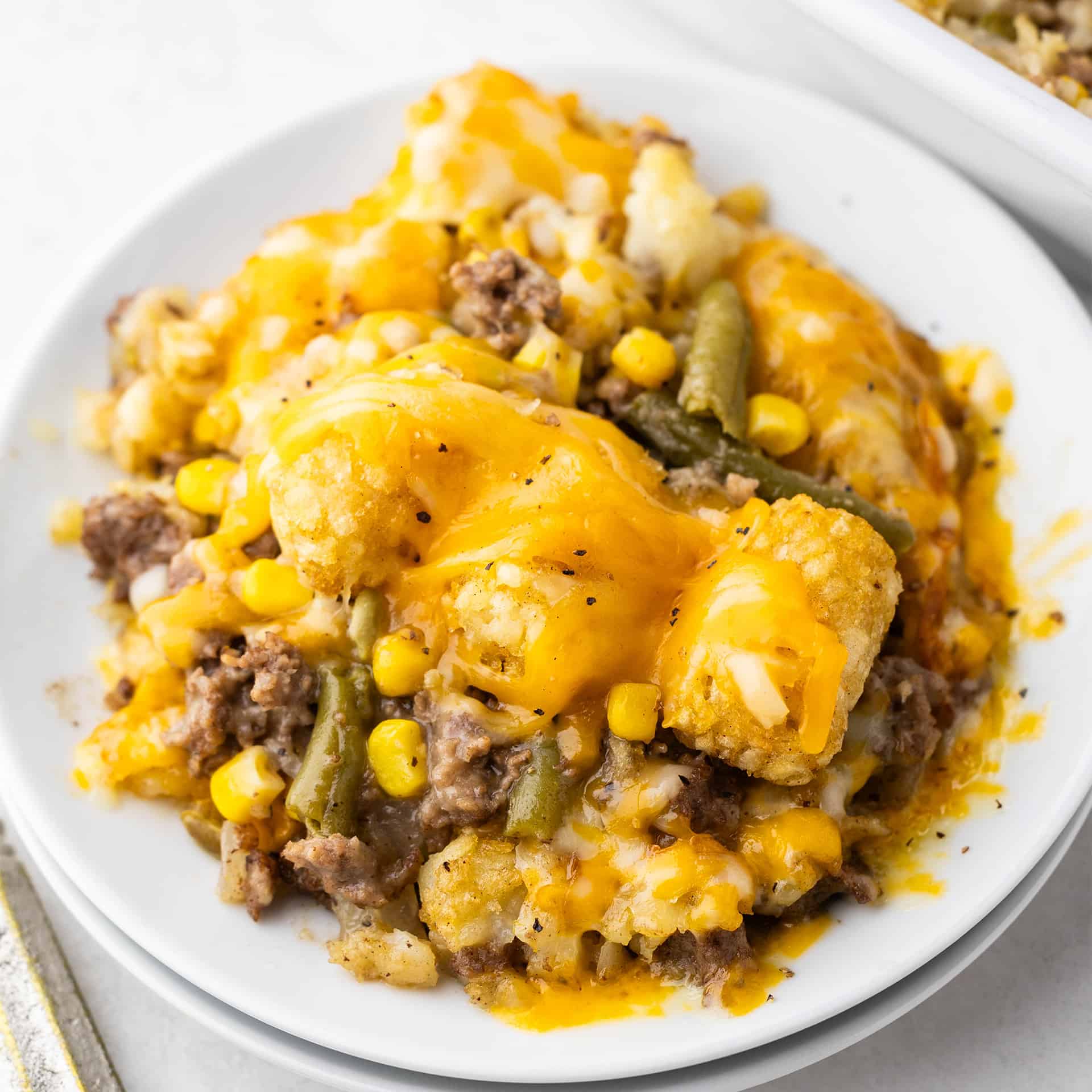 A serving of tater tot casserole on a white plate.