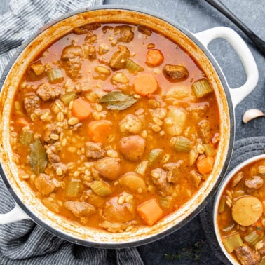 Overhead view of beef and barley soup in a large stockpot.