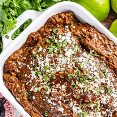 Overhead view of black bean dip in a white baking dish.