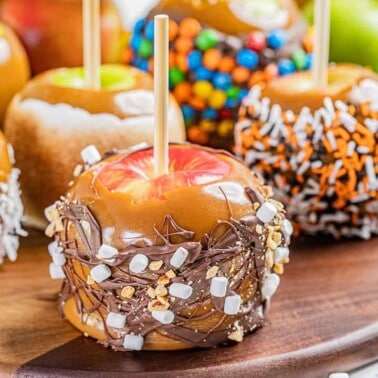 Close up view of caramel apples with various toppings.